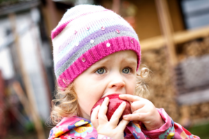 Holiday Hunger Appeal: little girl eating an apple